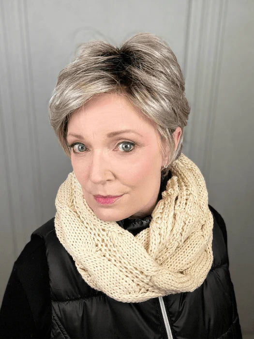 Woman wearing Ellen Wille Raise wig short silver gray layered pixie with dark roots cream knit scarf