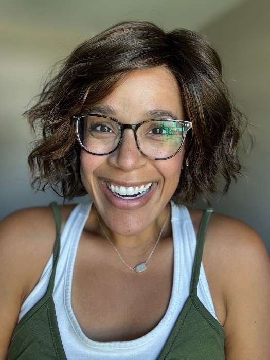 Ellen Wille Dance wig in a stylish short curly cut worn by a smiling woman with glasses
