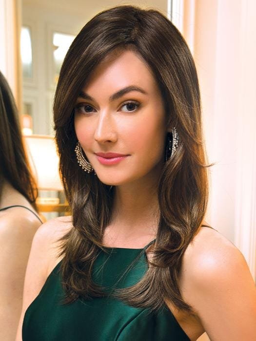 Brandi Amore wig long layered brown hair with side part subtle waves on model wearing green dress